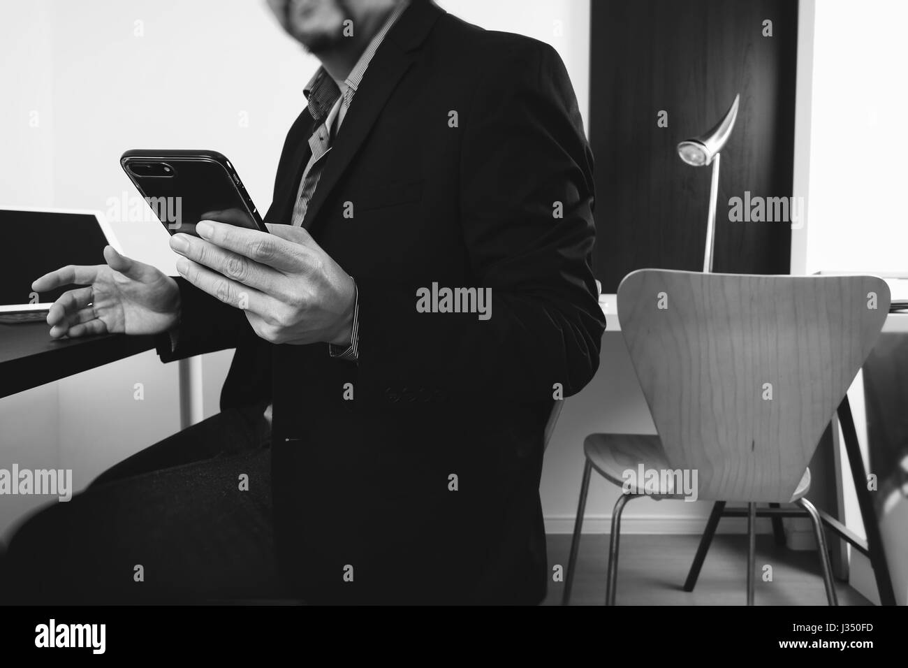 businessman working with smart phone and digital tablet and laptop computer in modern office,black and white Stock Photo