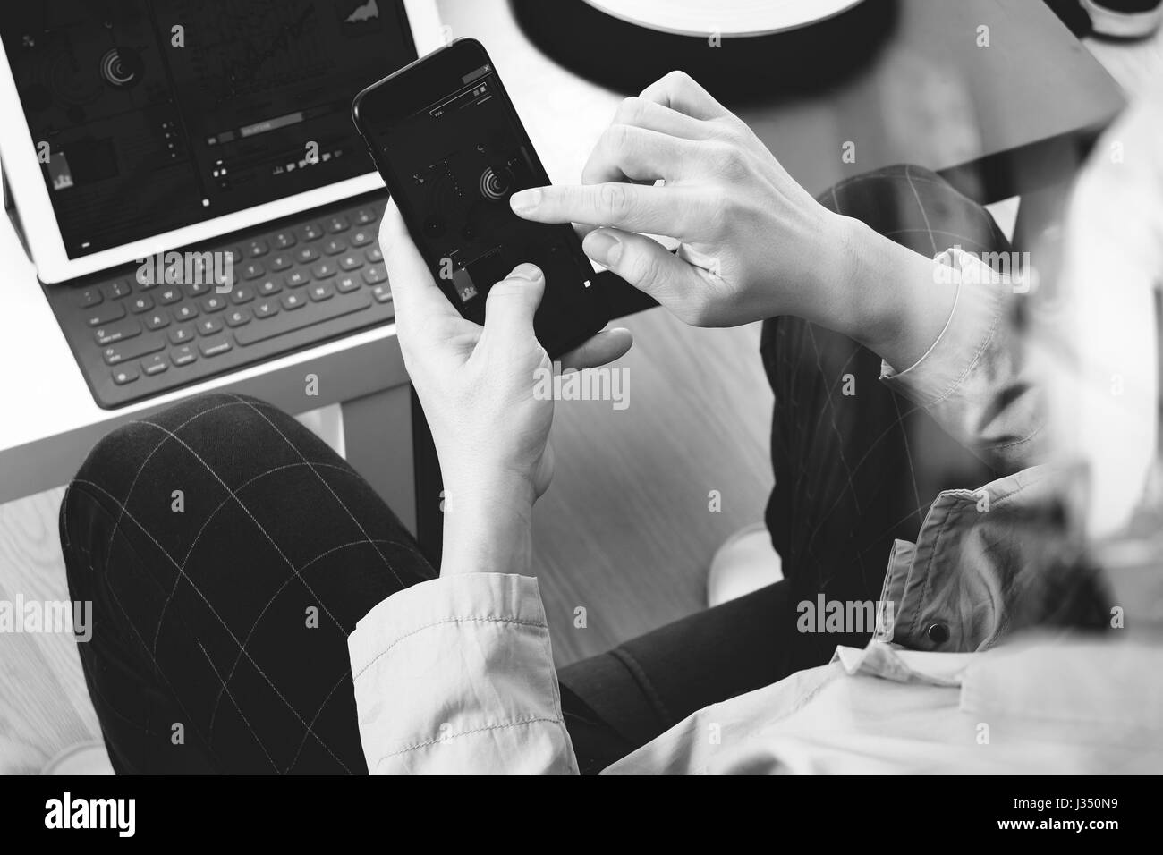 hand using smart phone and digital tablet computer for online banking payment communication in modern office,black and white Stock Photo