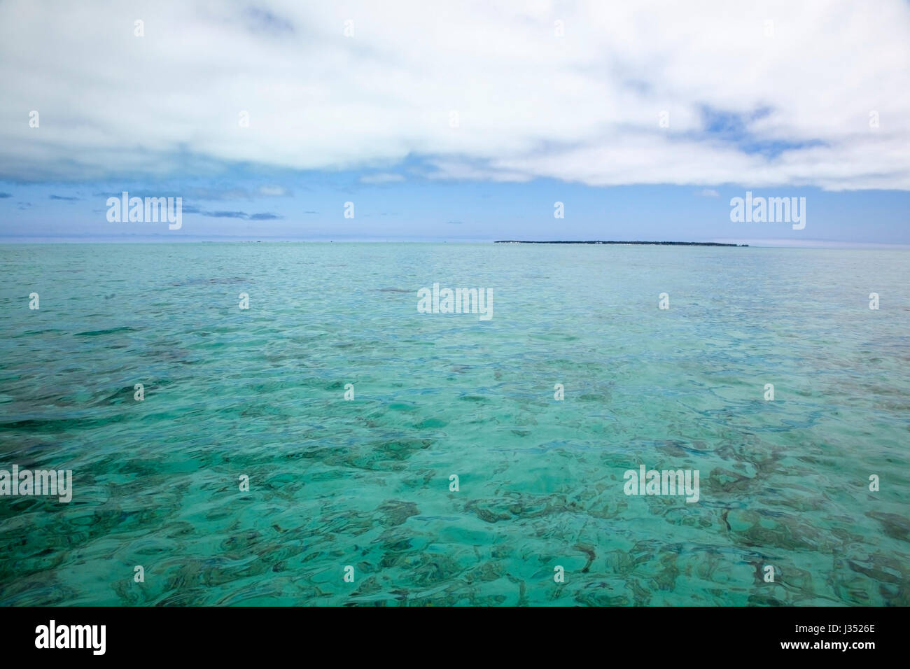 Remote Pacific island in the aquamarine water of Midway Atoll lagoon 