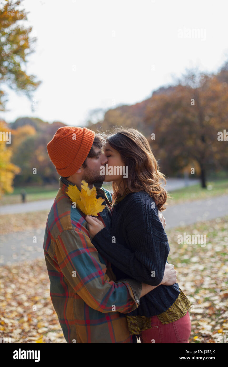 Happy young couple embracing in a park Stock Photo - Alamy