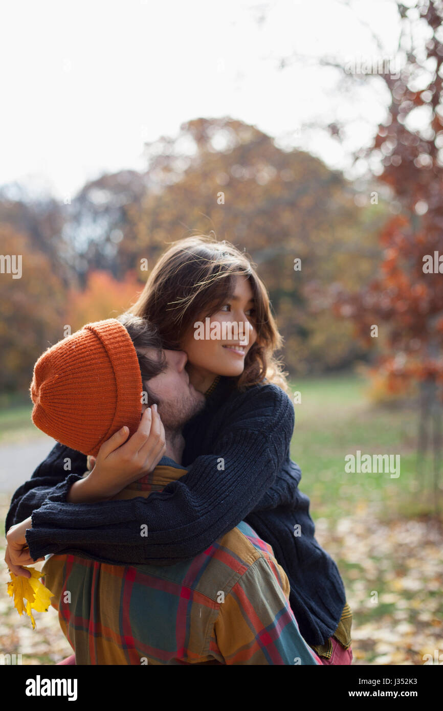 Happy young couple embracing in a park Stock Photo - Alamy