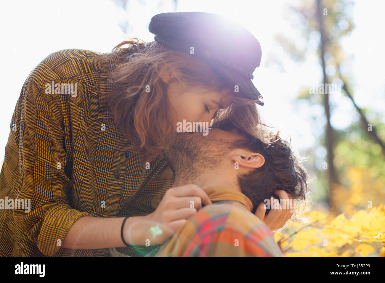 Happy young couple kissing in a park Stock Photo - Alamy