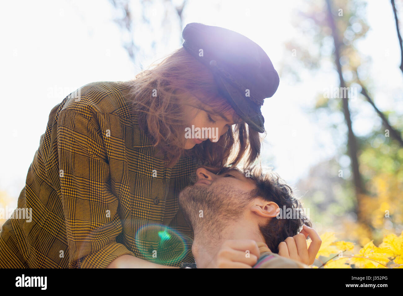 Happy young couple kissing in a park Stock Photo - Alamy