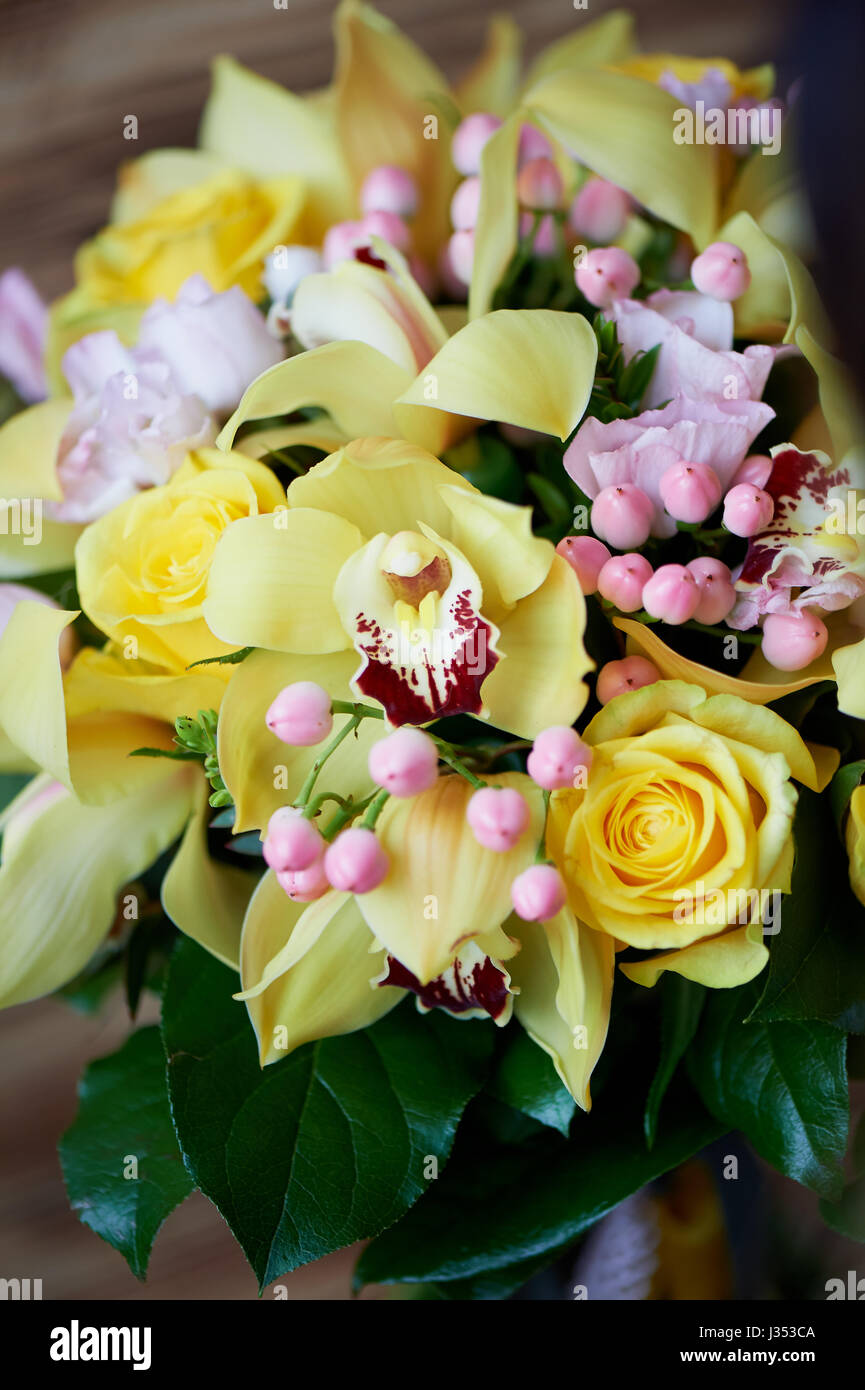 Fresh yellow bouquet of yellow roses and pink berries.Bright colors Stock Photo