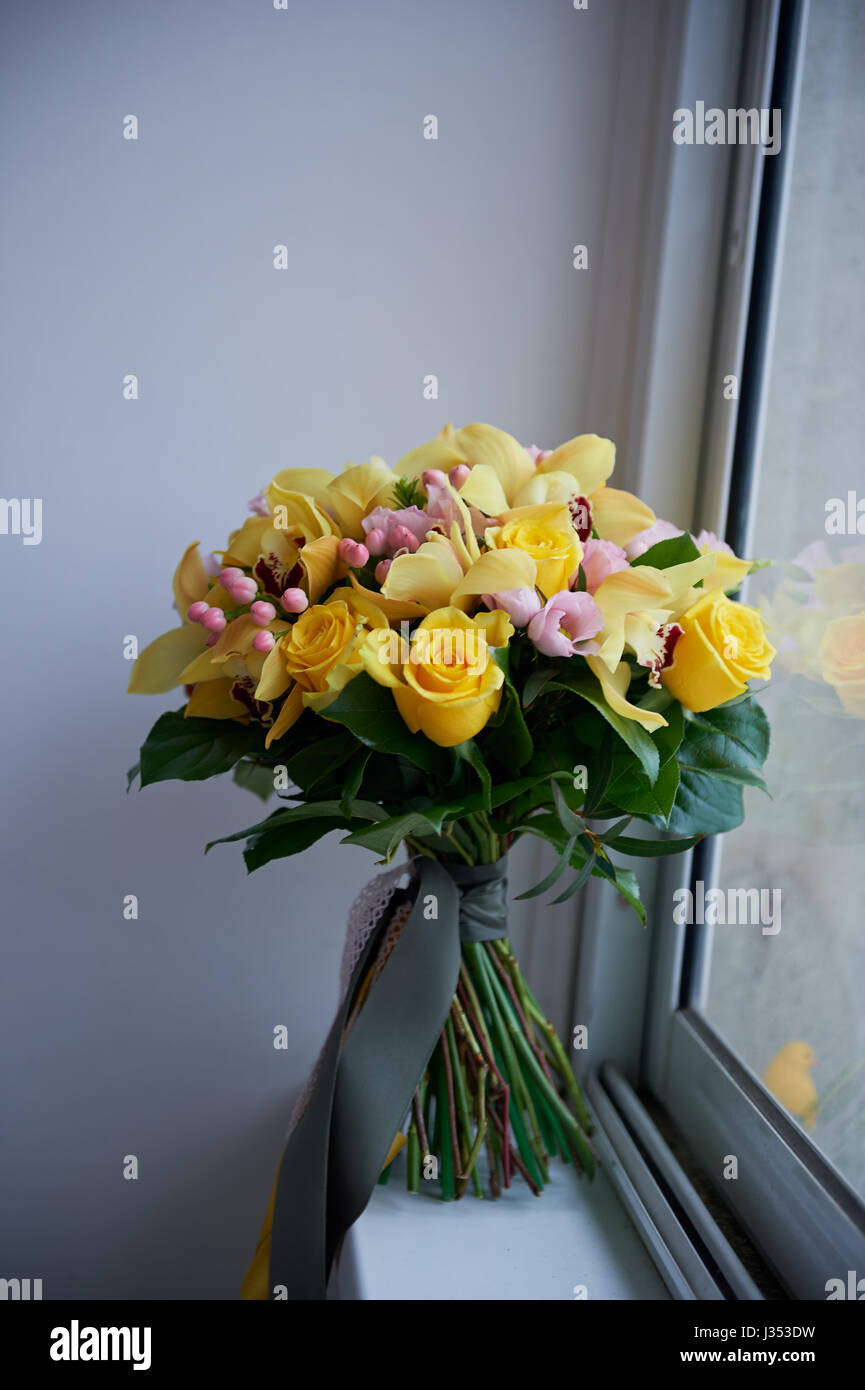 Fresh yellow bouquet of yellow roses and pink berries.Bright colors Stock Photo