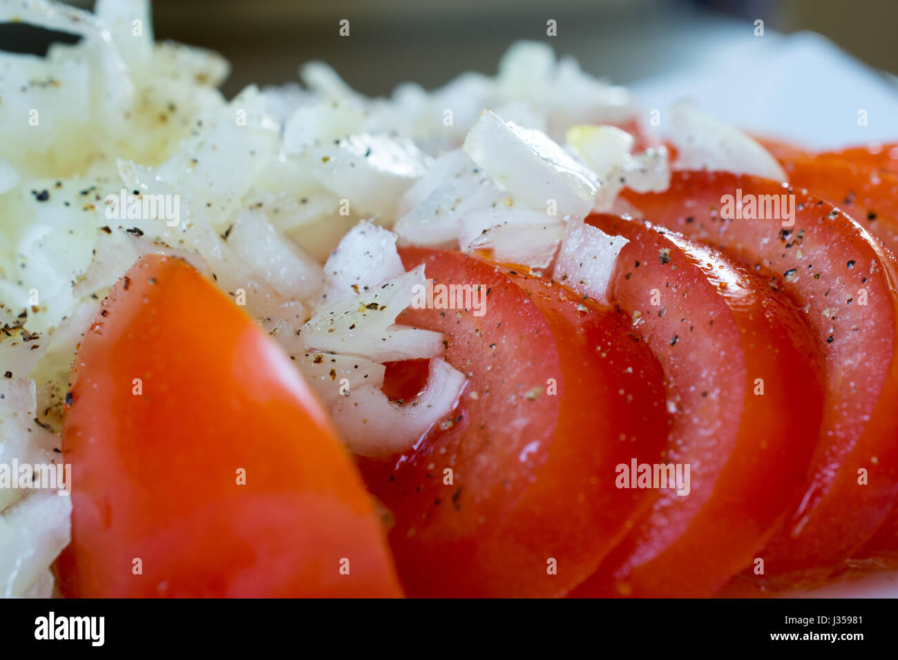 Tomato slices with onion and pepper close up Stock Photo - Alamy