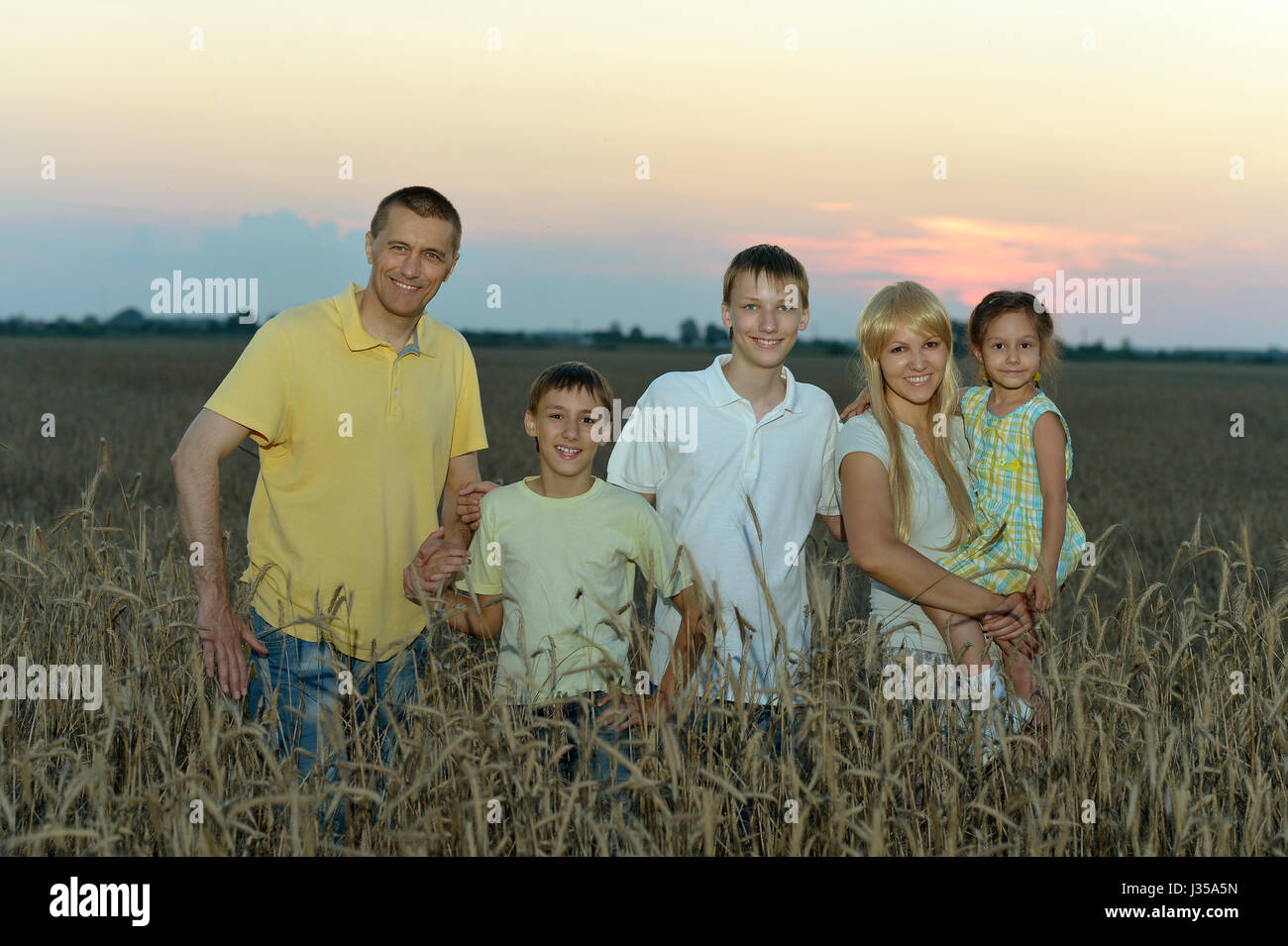 Happy parents with children at sunset Stock Photo