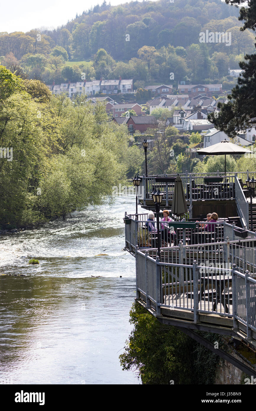People enjoying the weather and scenic views across the River Dee at Llangollen from The Royal Hotel on the banks of River in North Wales Stock Photo