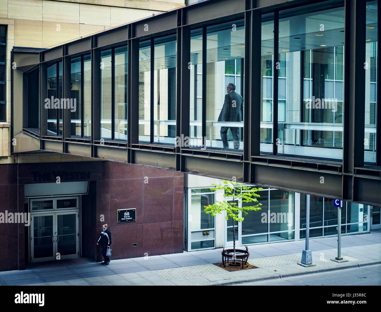 May 3, 2017 - Minneapolis, Minnesota, U.S - The skyway going into the Soo Line Building, a historic building renovated into upscale apartments. The skyways are enclosed pedestrian overpasses that connect downtown buildings. The Minneapolis Skyway was started in the early 1960s as a response to covered shopping malls in the suburbs that were drawing shoppers out of the downtown area. The system grew sporadically until 1974, when the construction of the IDS Center and its center atrium, called the Crystal Court, served as a hub for the downtown skyway system. There are 8 miles of skyways, connec Stock Photo