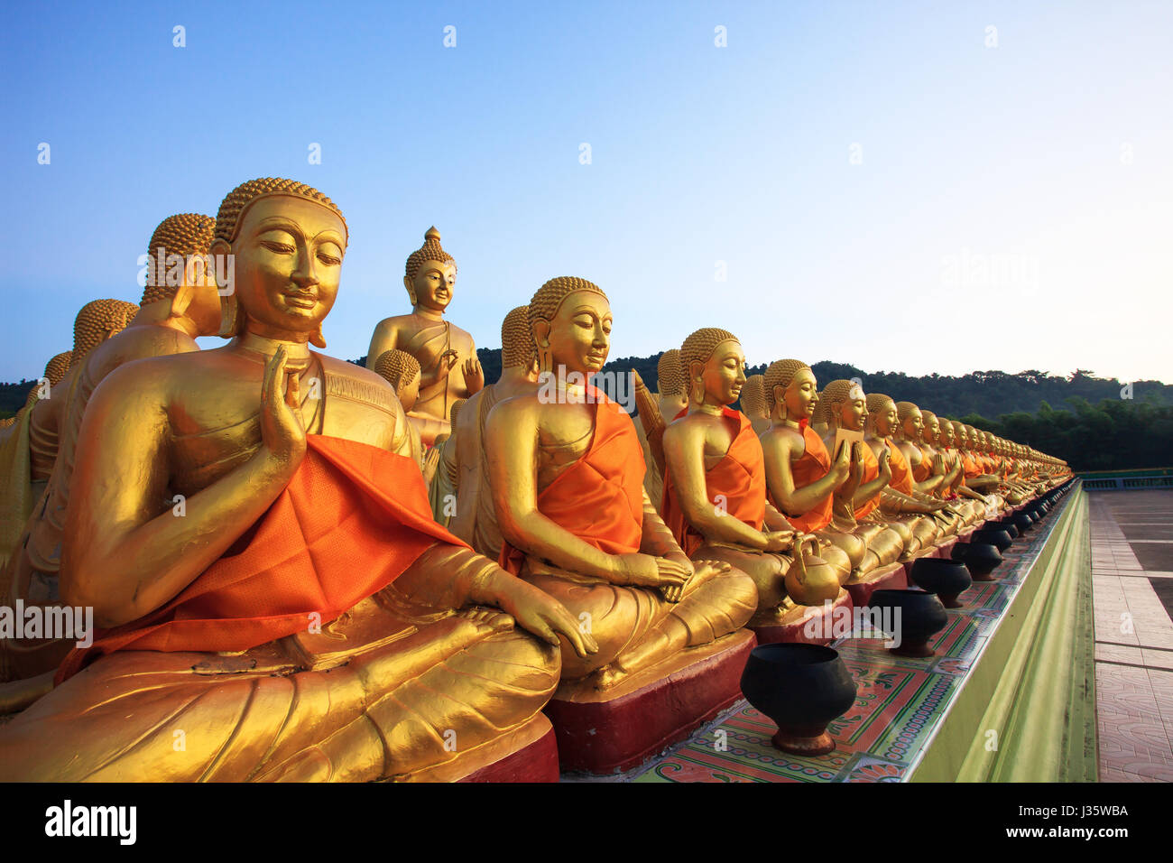 golden buddha statue in buddhism temple thailand against fade blue sky ...