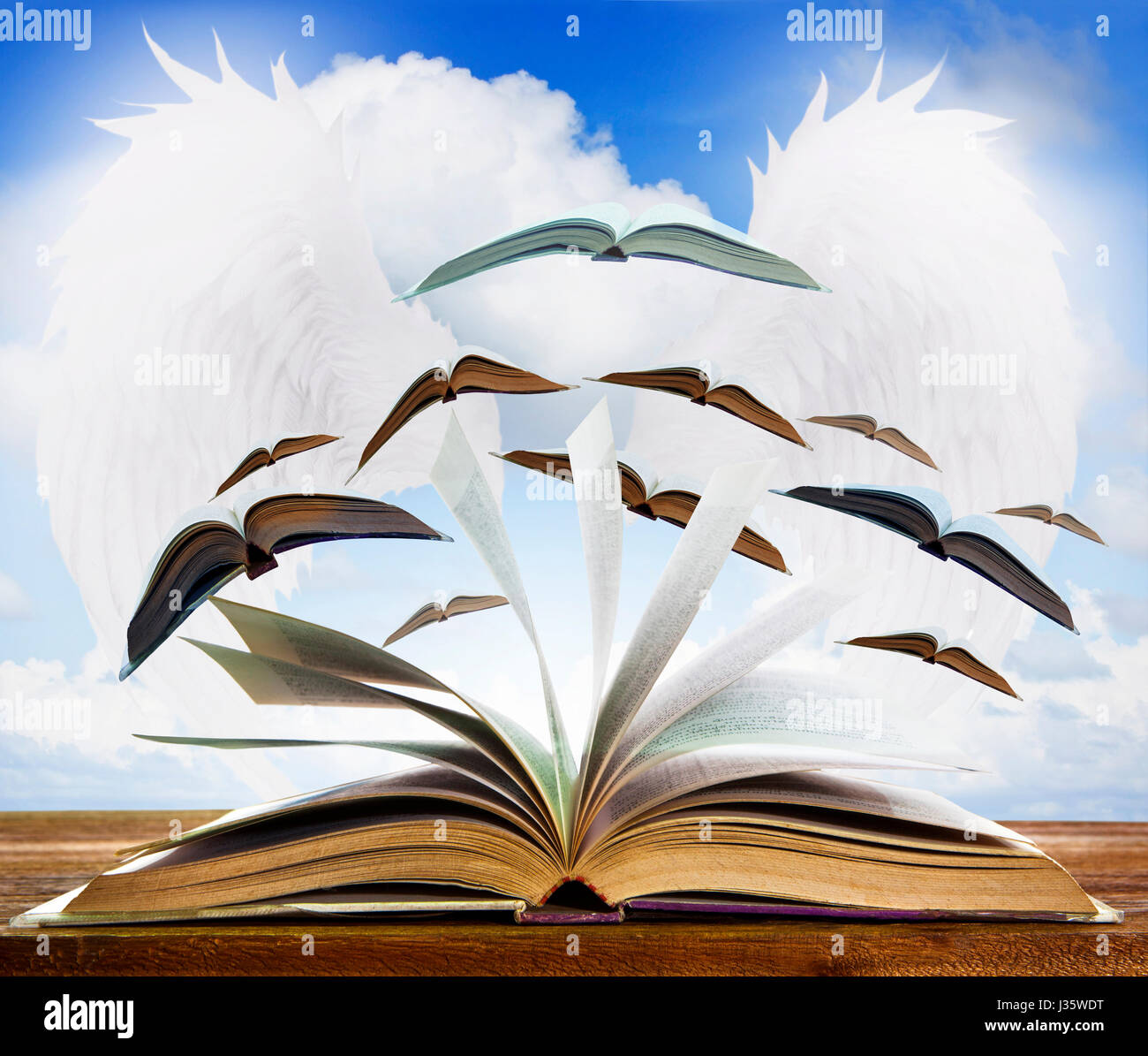 open old book page on wood table with flying book page against