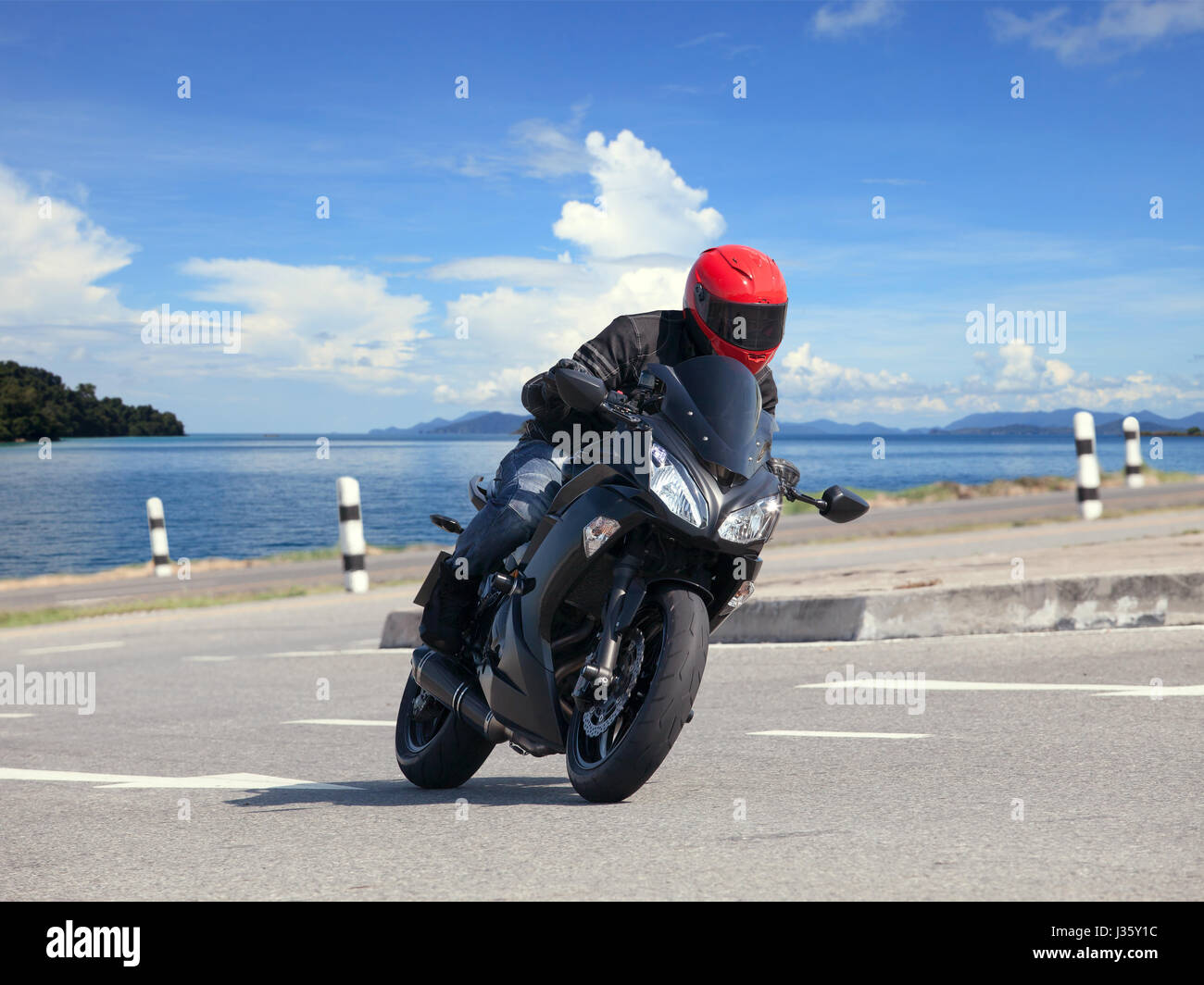 young man riding big bike motorcycle against sharp curve of