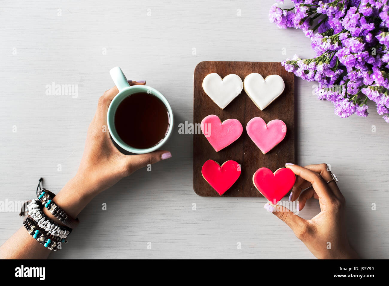 People Hands Showing Heart Shape Cookies with Coffee Cup Stock Photo