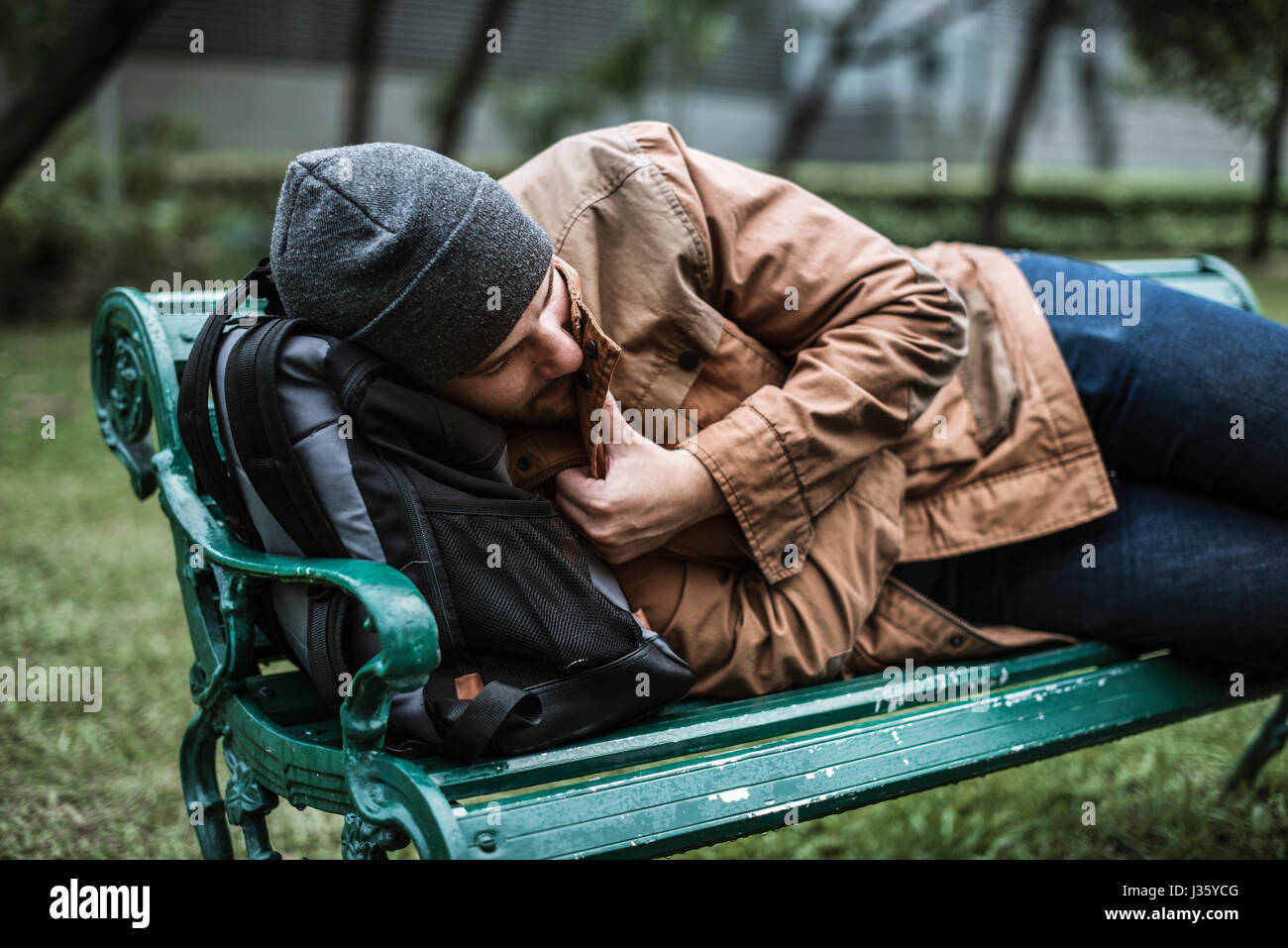 Homeless Adult Man Sleeping on Bench in The Park Stock Photo - Alamy