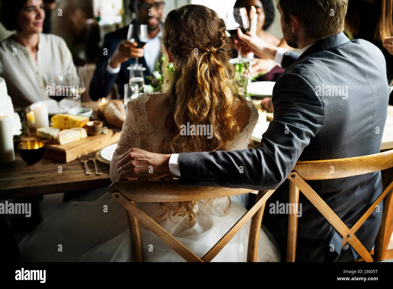 Bride and Groom Having Meal with Friends at Wedding Reception Stock Photo