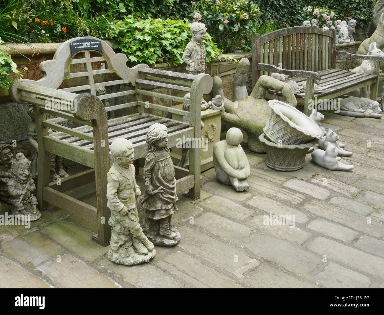 Cobbled courtyard of a shop in Montpellier Mews in Montpellier, Harrogate, Yorkshire, selling garden ornaments, including a grotesque Punch and Judy. Stock Photo