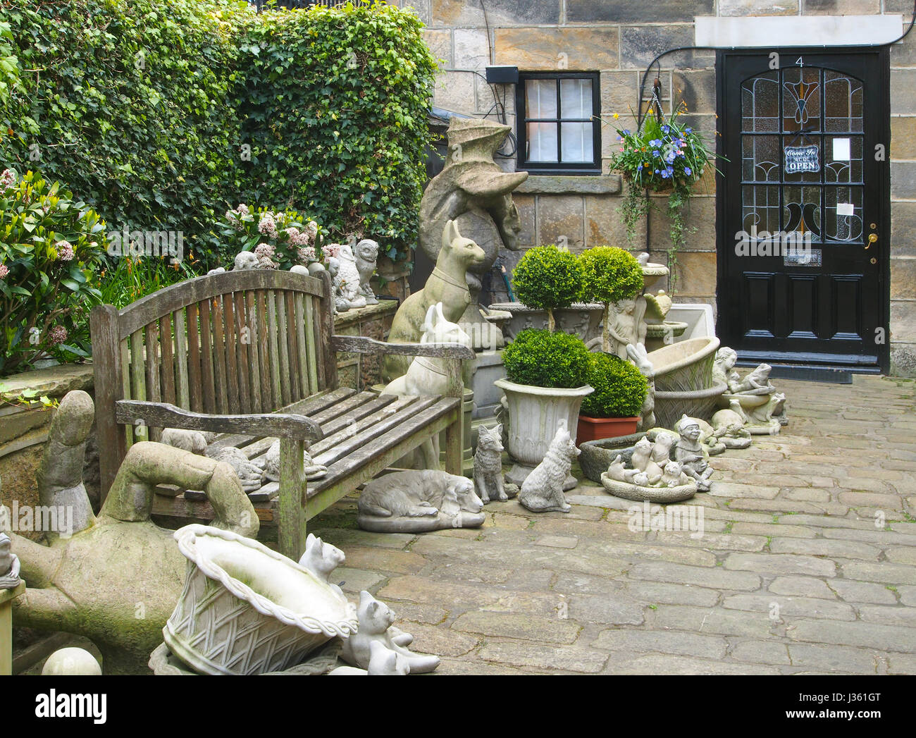 Cobbled courtyard of a shop in Montpellier Mews in Montpellier, Harrogate, Yorkshire, selling garden ornaments, including a grotesque Punch and Judy. Stock Photo