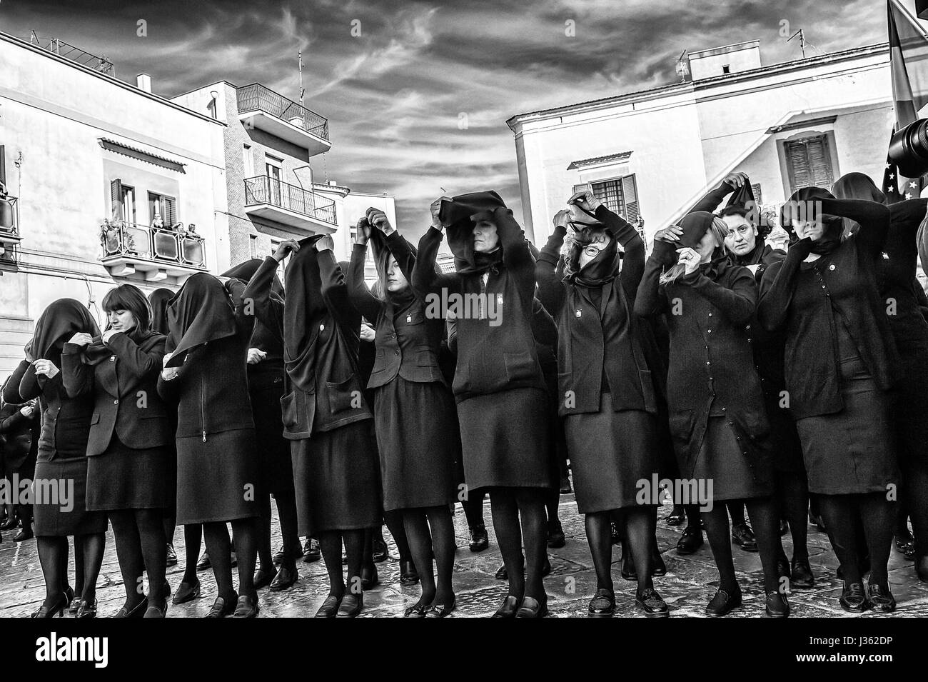 The women in black who will follow the Madonna Desolata in procession raise the black veil that will cover the entire their face Stock Photo