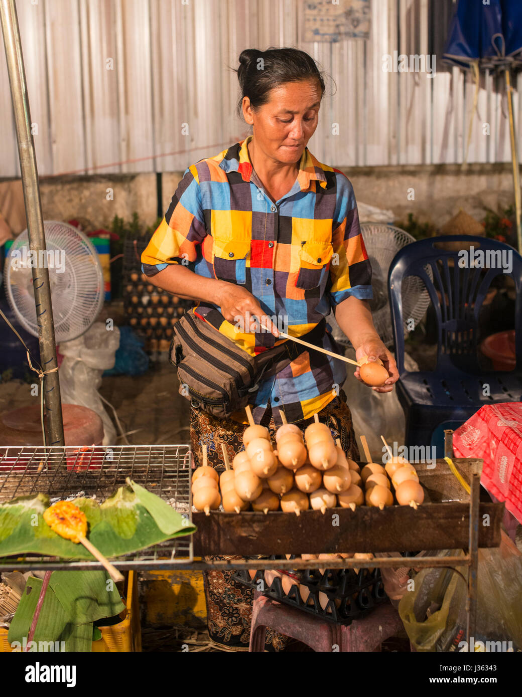 Laotian woman skewering dough, Vientiane Stock Photo