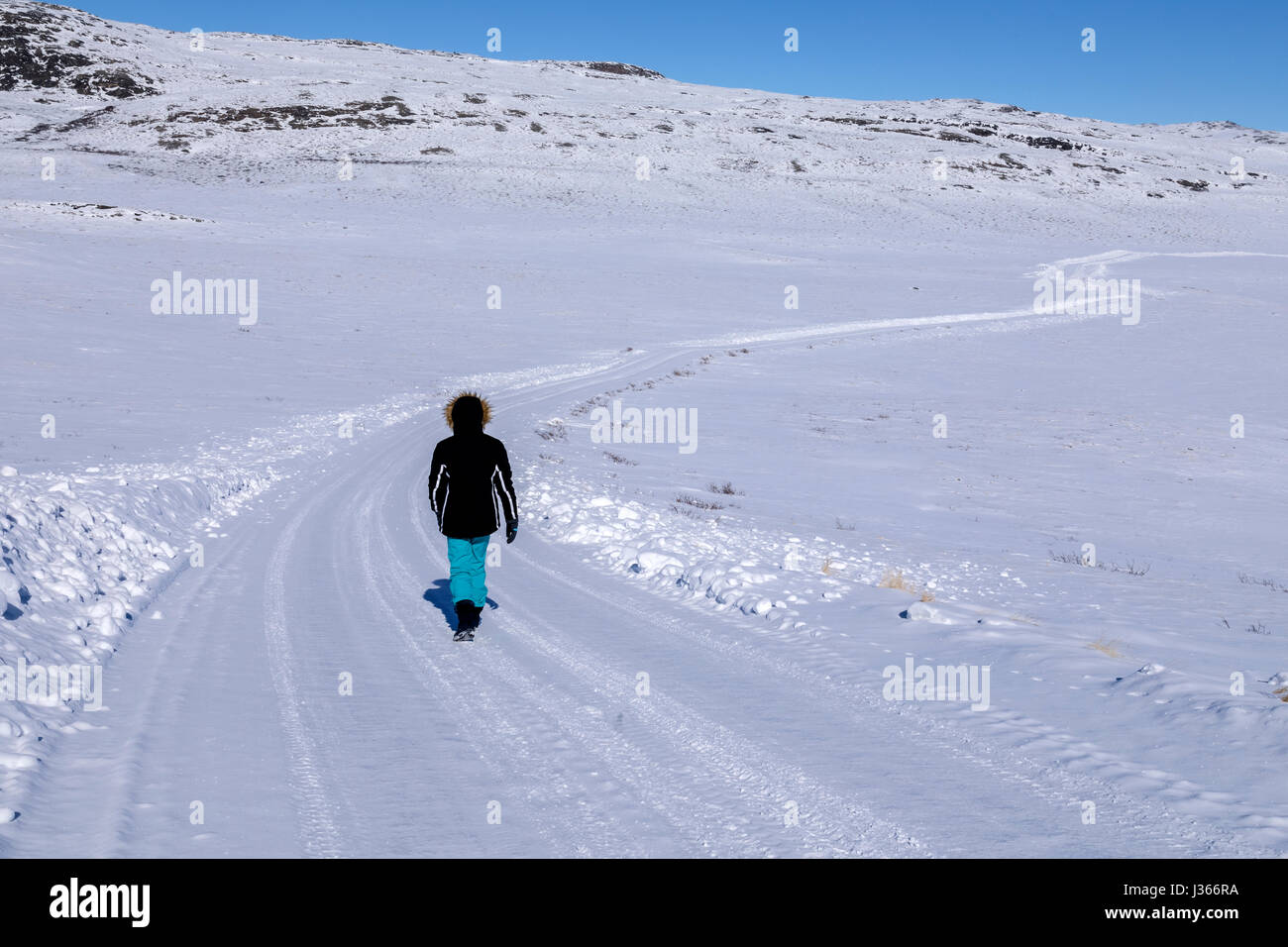 a person walking on a snowy road Stock Photo