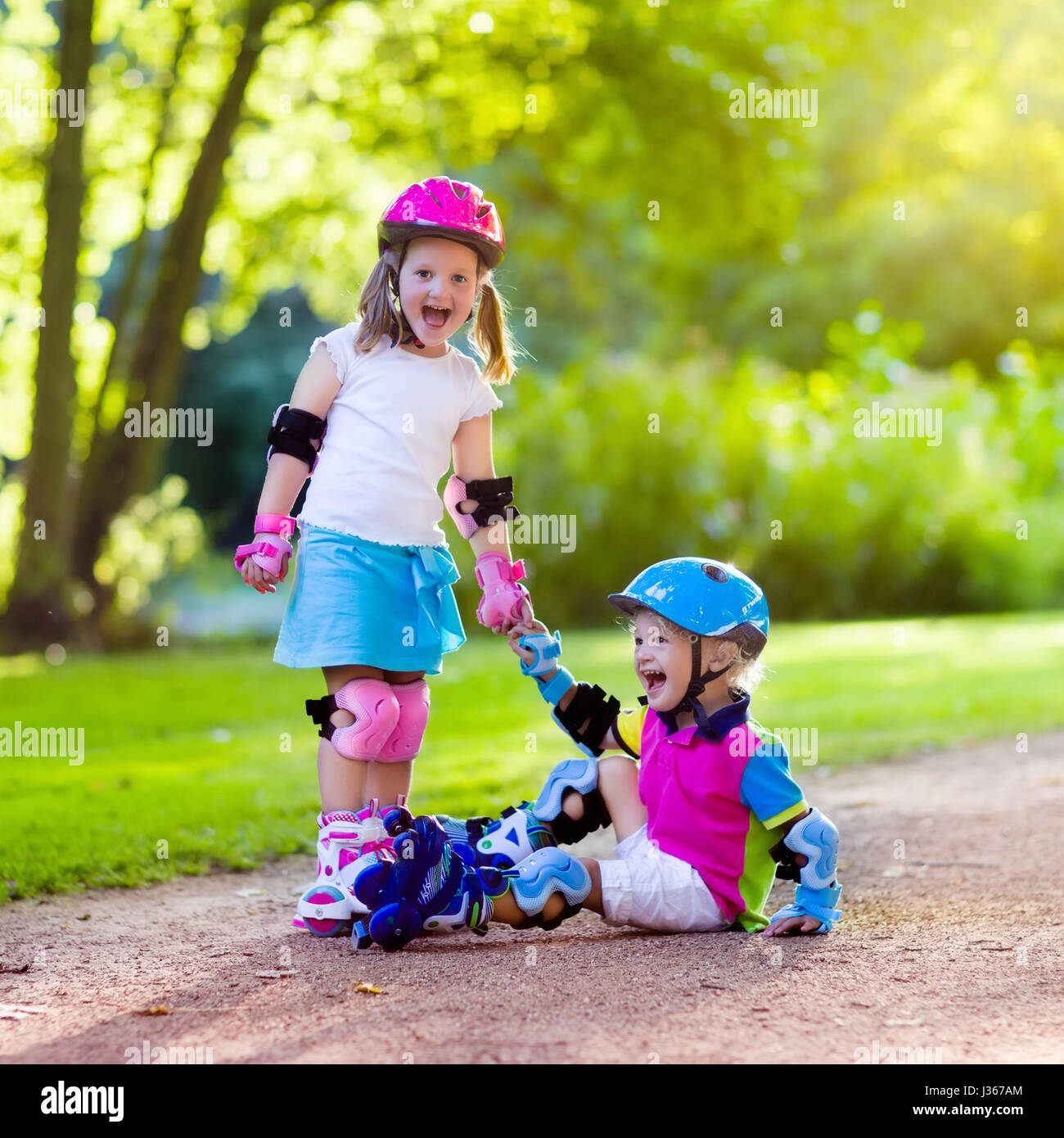 Girl and boy learn to roller skate in summer park. Children wearing