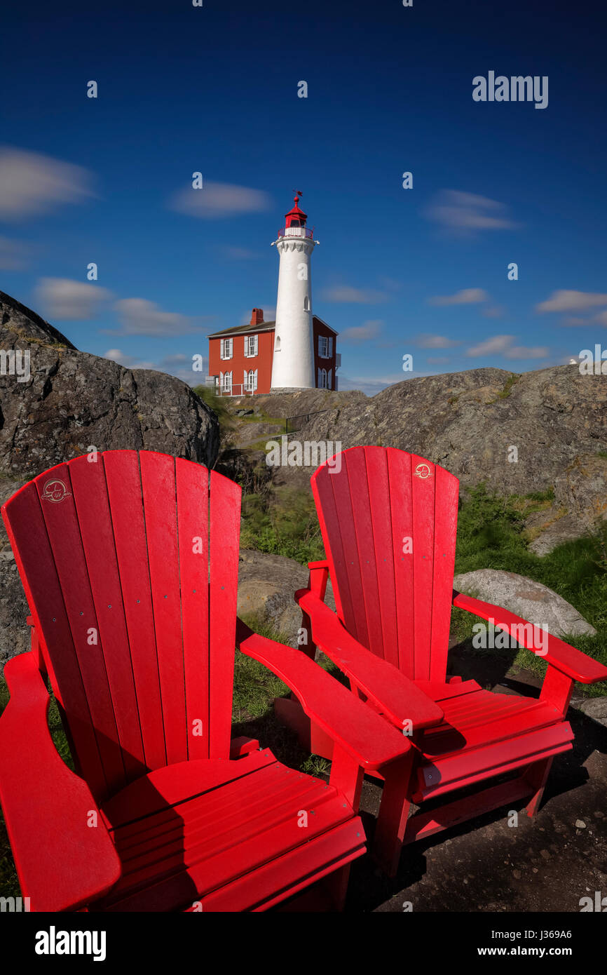 Parks Canada red deckchairs and Historic Fisgard Lighthouse in late afternoon light-Fort Rodd Hill, Victoria, British Columbia, Canada. Stock Photo