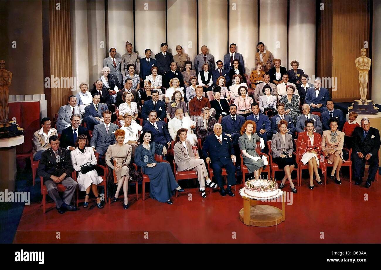 Actors under contract with MGM at the studio's 20th birthday party, in 1943.    Front Row: James Stewart, Margaret Sullavan, Lucille Ball, Hedy Lamarr, Katharine Hepburn, Louis B Mayer, Greer Garson, Irene Dunne, Susan Peters, Ginny Simms, Lionel Barrymore.  Second Row: Harry James, Brian Donlevy, Red Skelton, Mickey Rooney, William Powell, Wallace Beery, Spencer Tracy, Walter Pidgeon, Robert Taylor, Pierre Aumont, Lewis Stone, Gene Kelly, Jackie Jenkins.  Third Row: Tommy Dorsey, George Murphy, Jean Rogers, James Craig, Donna Reed, Van Johnson, Fay Bainter, Marsha Hunt, Ruth Hussey, Marjorie  Stock Photo