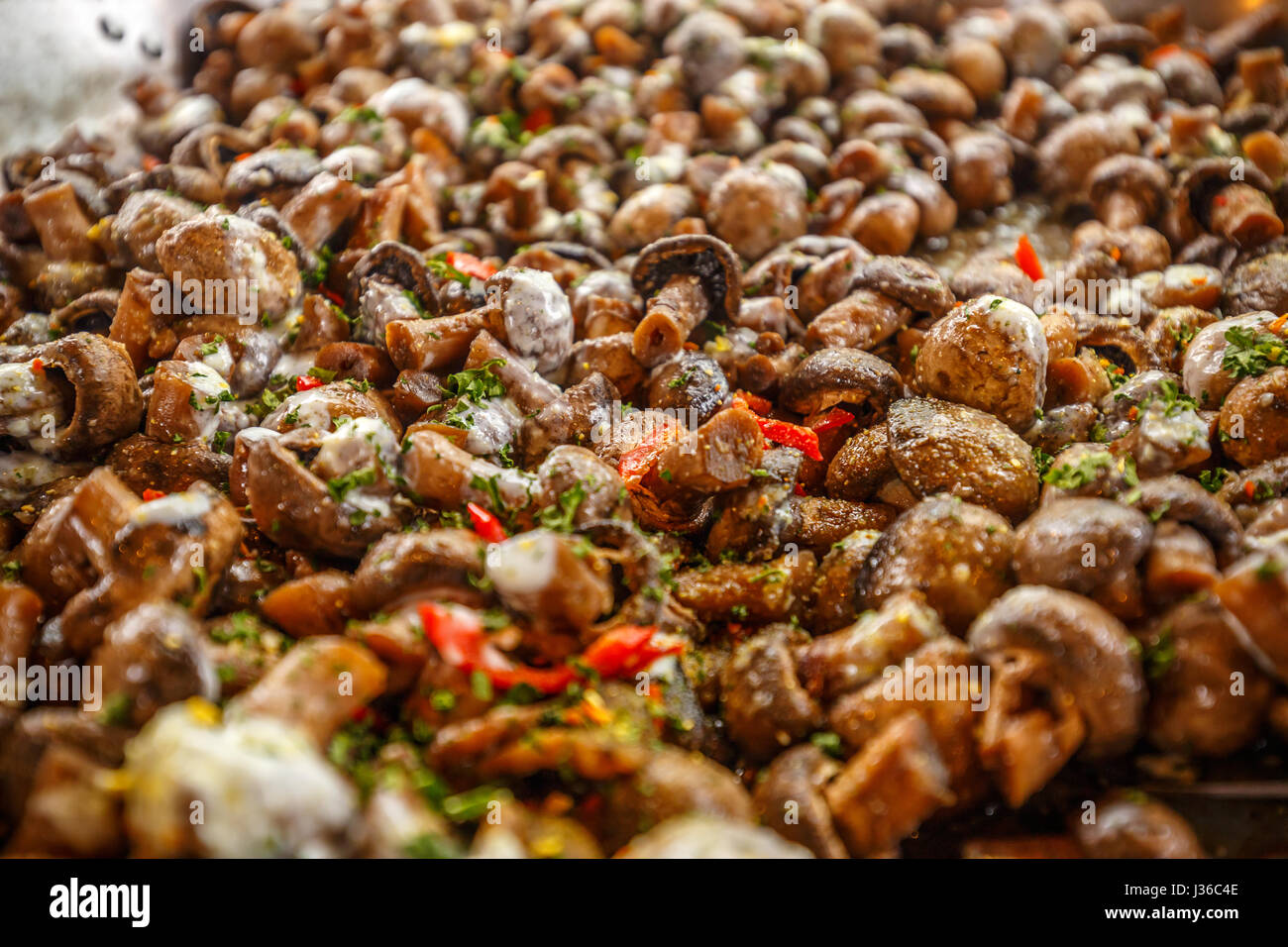 Champignon mushrooms cooked in big metal wok Stock Photo