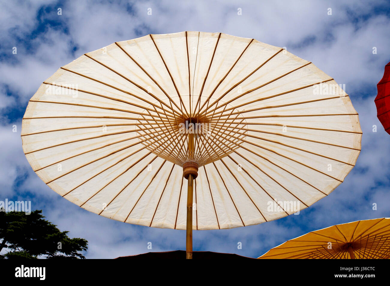 Colorful white sun umbrella against a blue sky Stock Photo