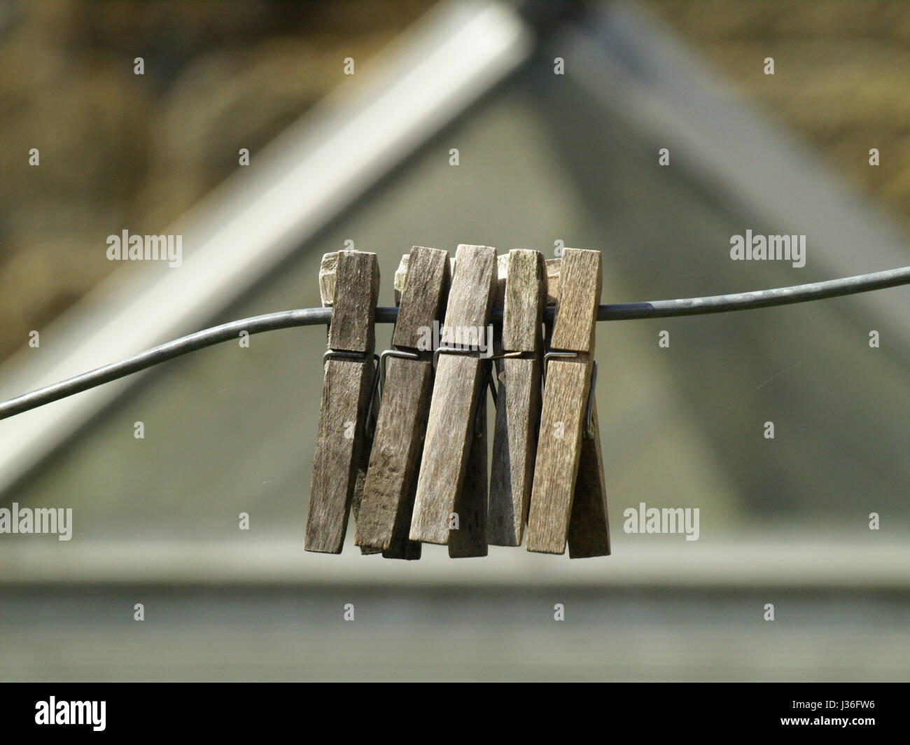Wooden clothes pegs on a wire washing line Stock Photo