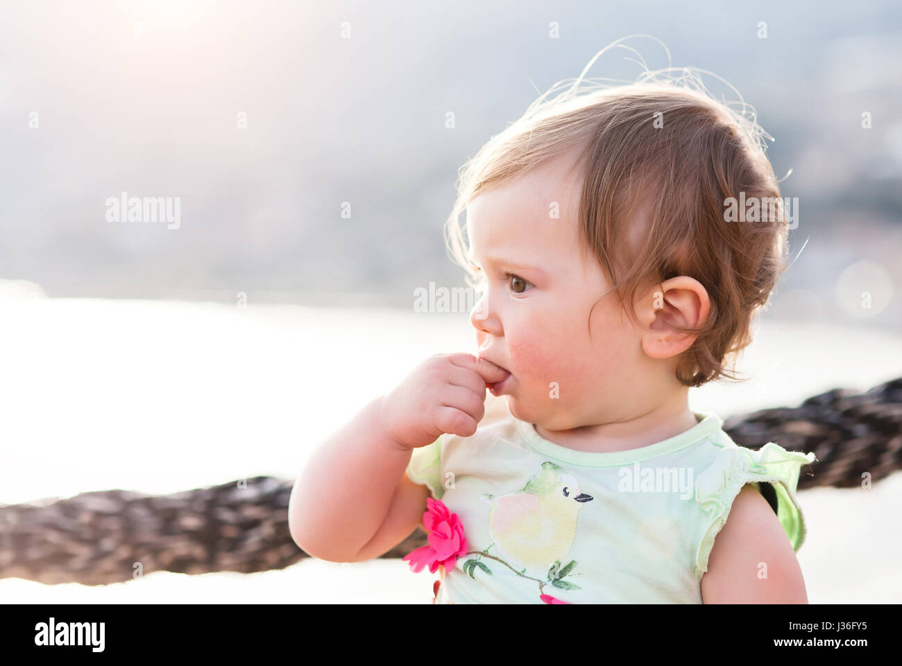 female 1 years old child look far at harbour Stock Photo