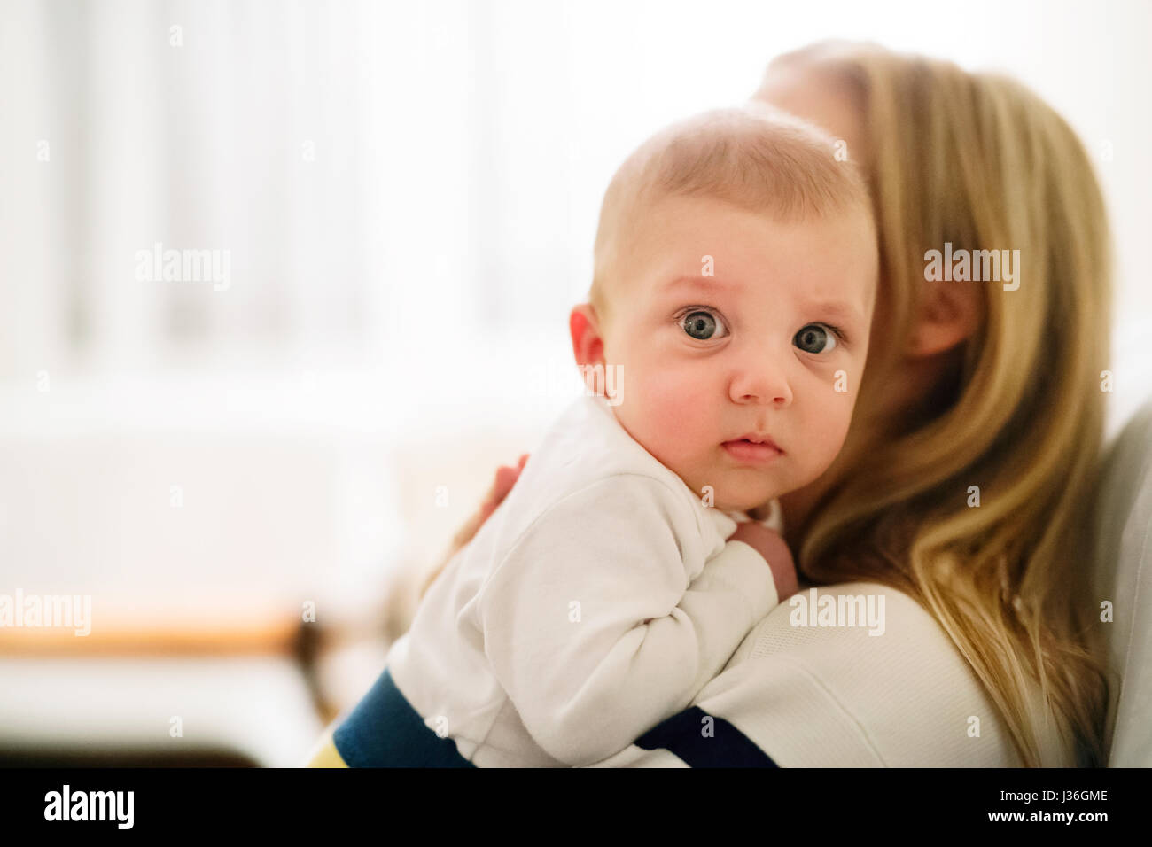 Beautiful young mother holding baby son in the arms Stock Photo - Alamy