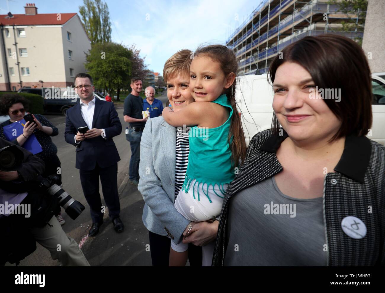 First Minister and SNP leader Nicola Sturgeon meets meets Lexi Adams, 4, outside her home in Toryglen, Glasgow, with SNP Glasgow Group Leader Susan Aitken (right) as she campaigns ahead of council elections on Thursday. Stock Photo