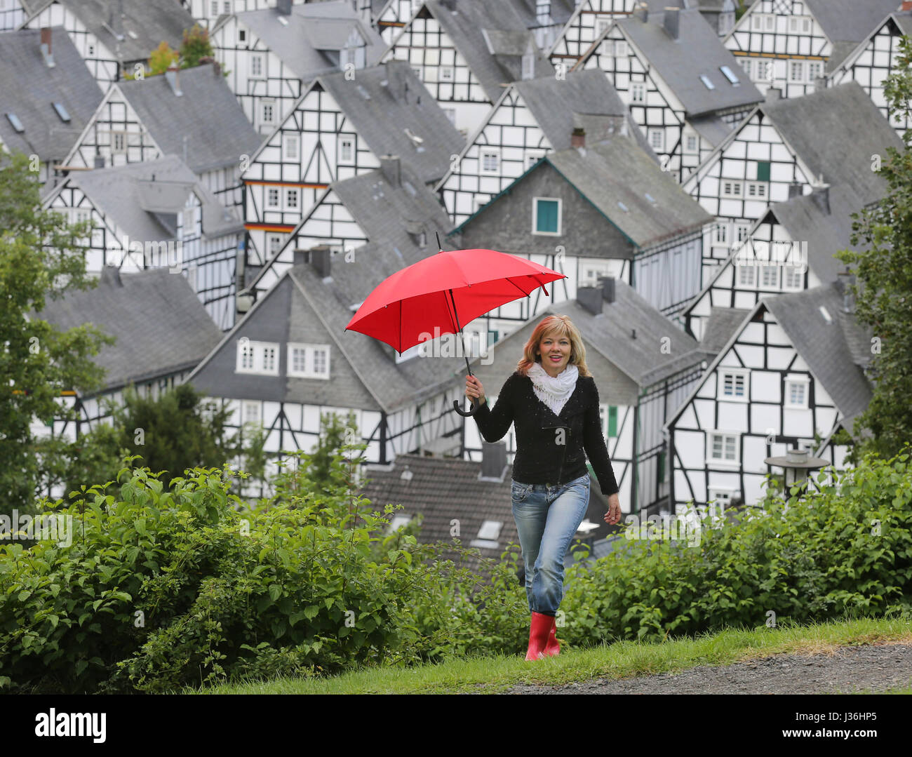 Germaney, a woman with an Red Umbrella walking in front of the city Freudenberg, Siegerland Stock Photo