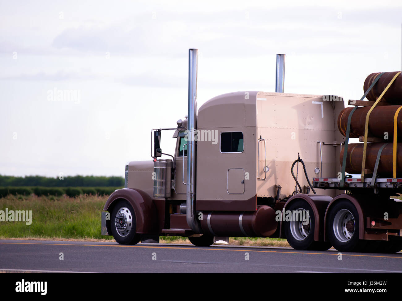 Powerful American classic professional brown semi truck rig with a flat ...