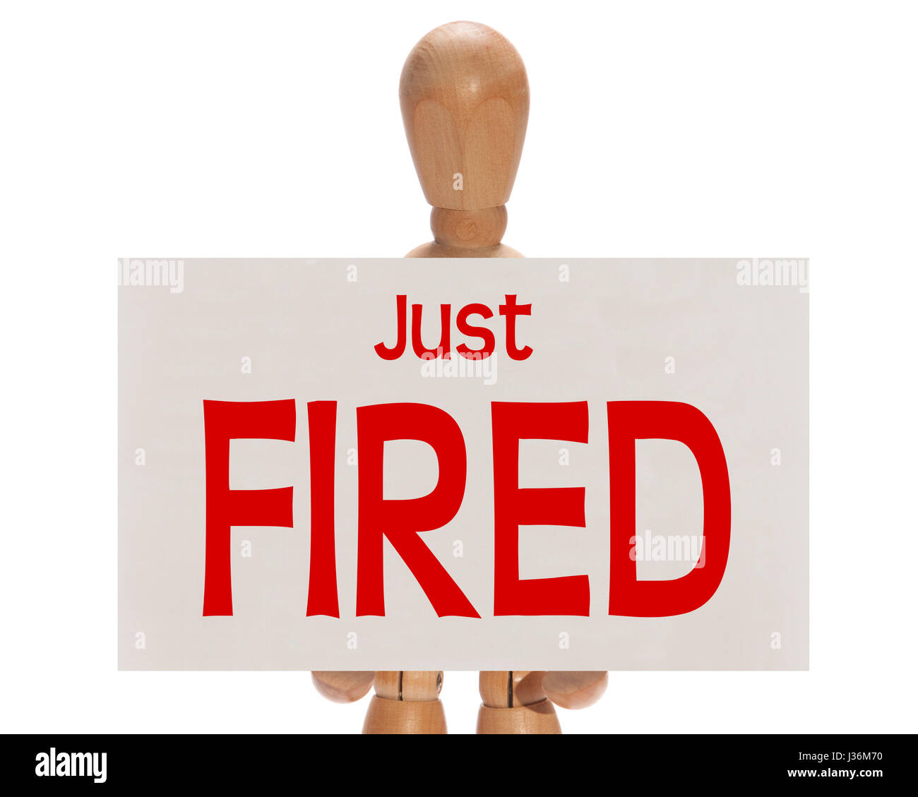 Wooden mannequin holding a white card with the message 'Just fired' over a white background Stock Photo