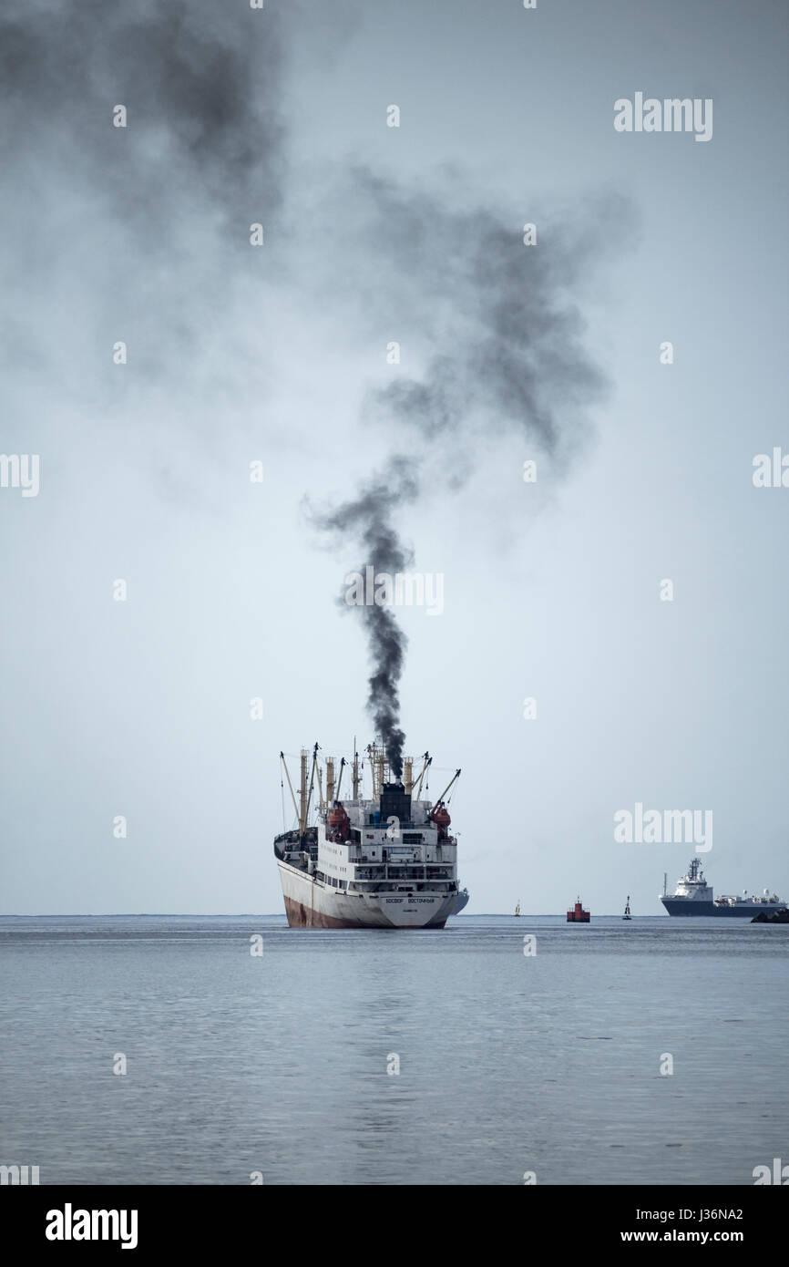 Black smoke from funnel of Russian trawler as ship leaves port. Stock Photo