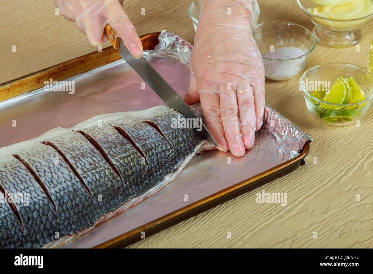 Woman marinated fillet fish cooking raw fish on kitchen onion dish in