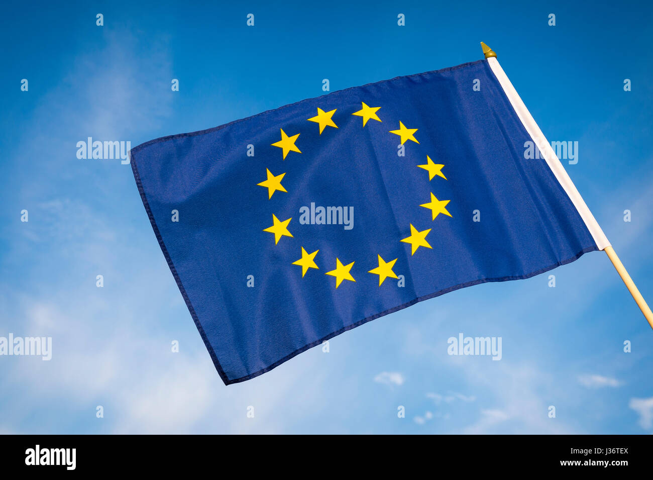 EU European Union flag flying outdoors in bright blue sky Stock Photo