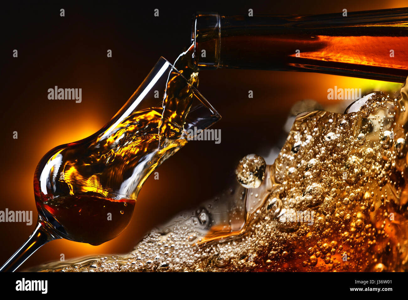 Pouring liquor into a glass . Wineglass and bottle on dark background