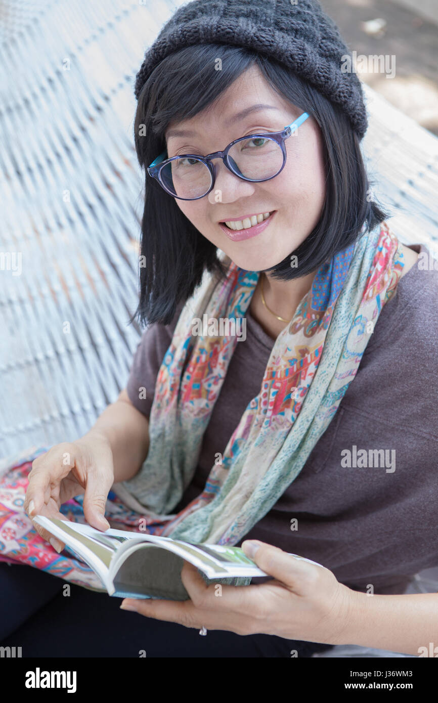 portrait of beautiful asian woman relaxing time reading book on cradle happiness emotion with smiling face Stock Photo