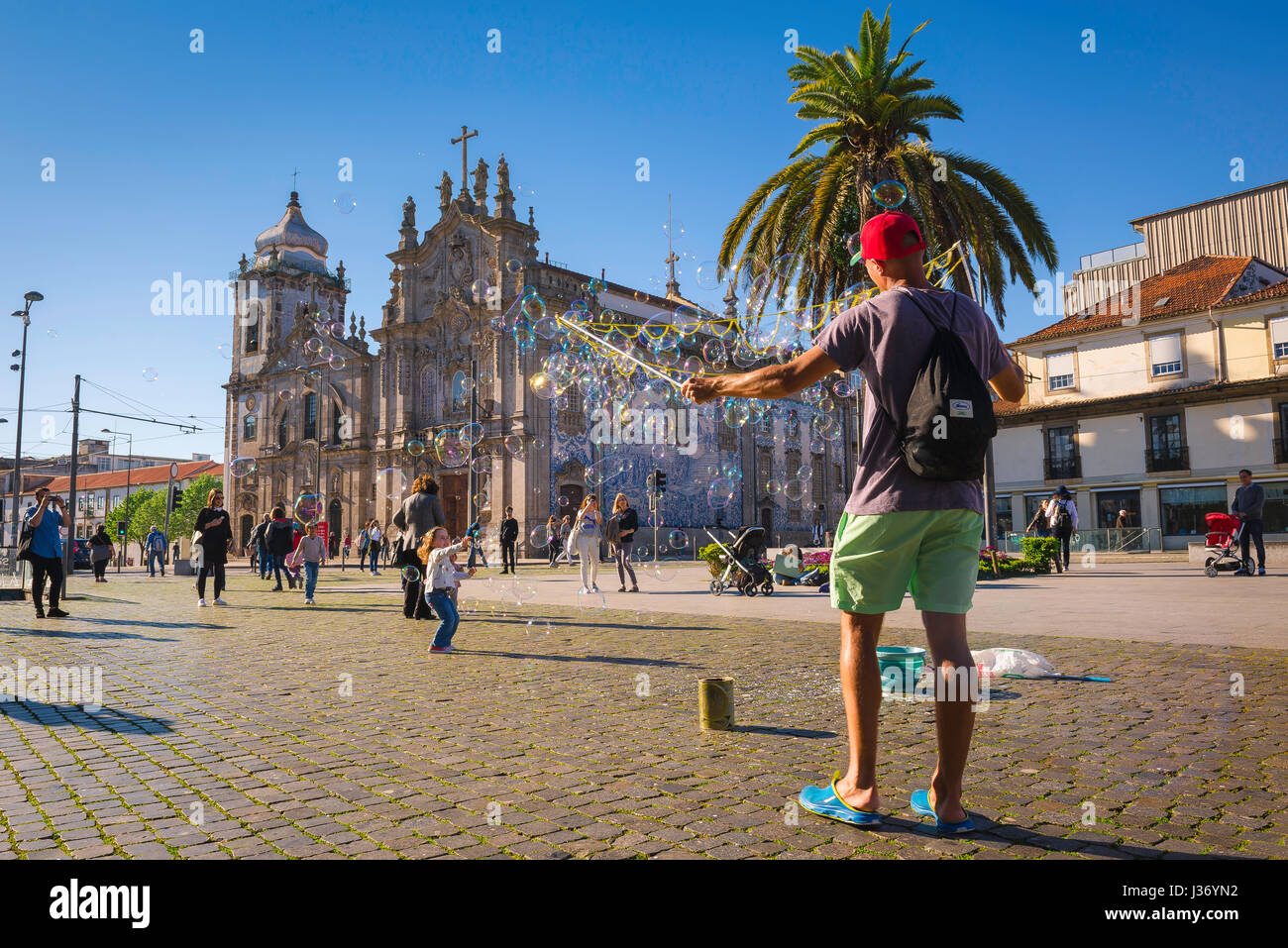 Porto Portugal city center, children have fun catching bubbles near the  Igreja do Carmo in the Praca de Gomez Teixeira square in the centre of  Porto Stock Photo - Alamy