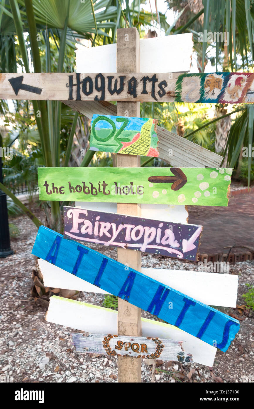 Signs on a post showing fictional places. Stock Photo