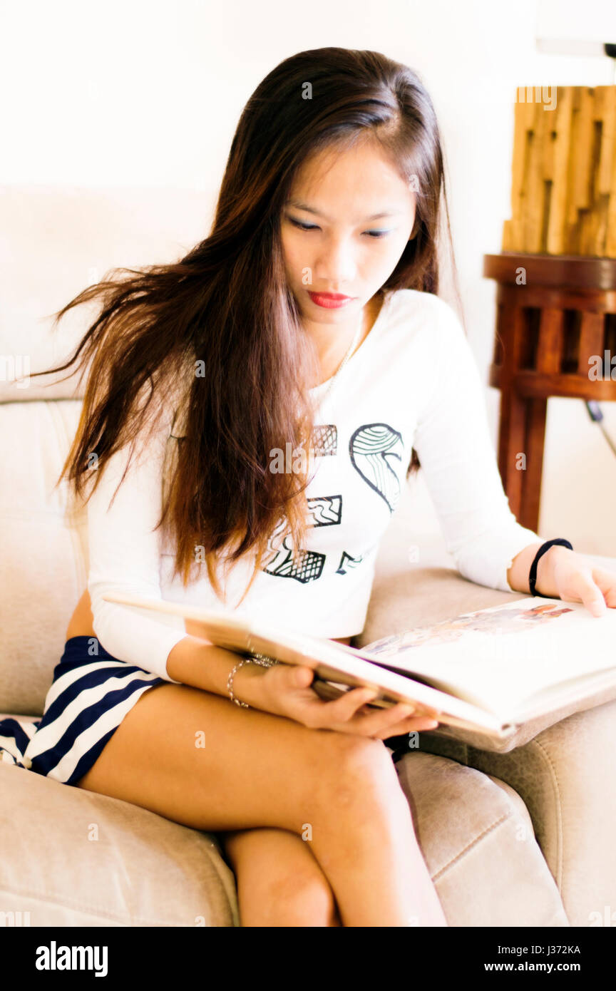 Young attractive Asian woman reading a book, in and indoors setting Stock Photo