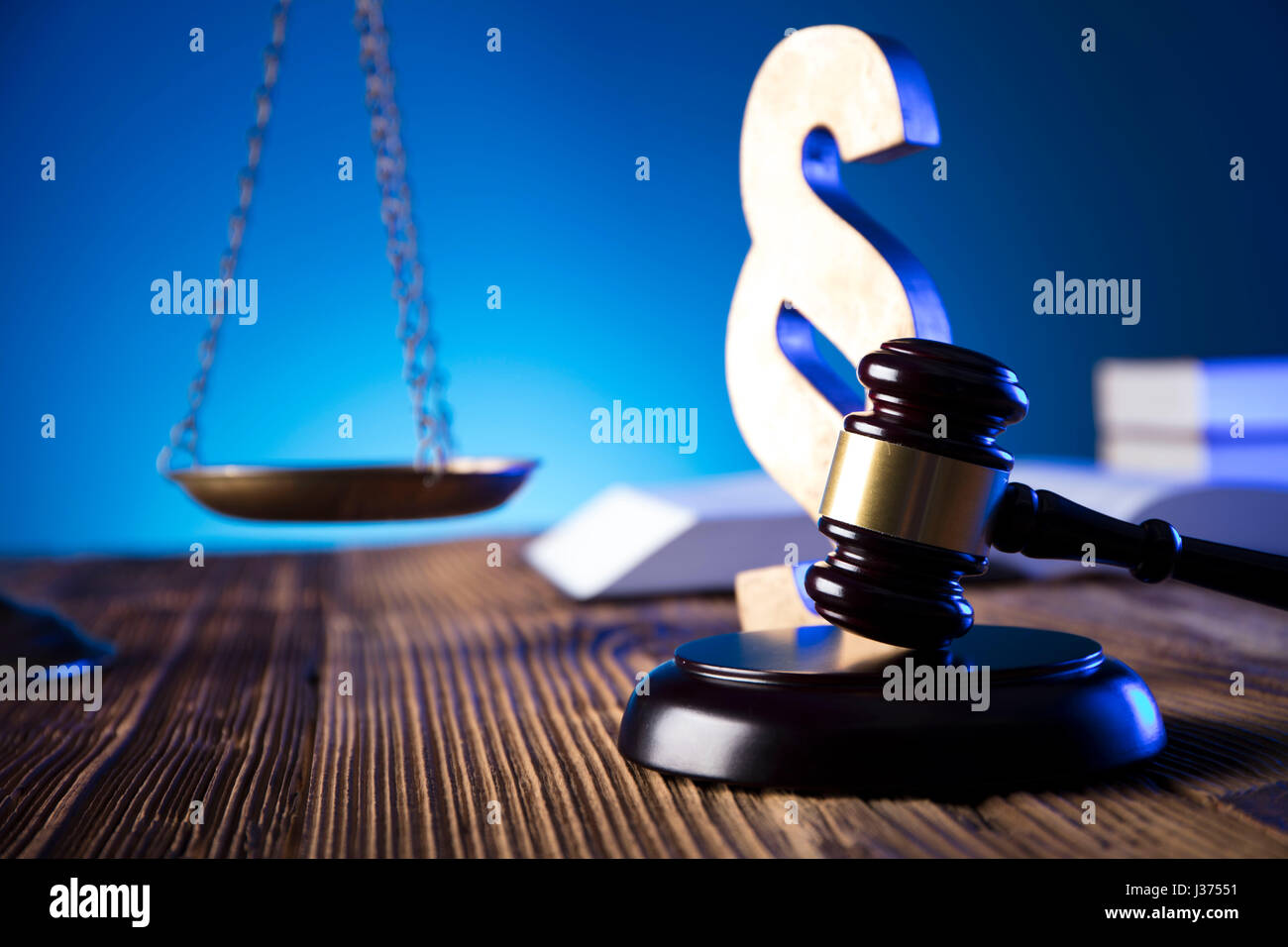 Scale of justice on old wooden table and blue background. Law theme and
