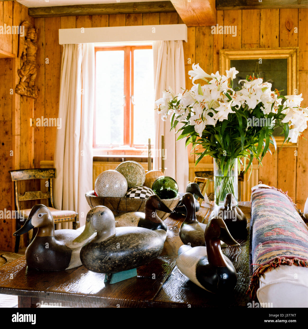Collection of duck ornaments on table in rustic living room. Stock Photo