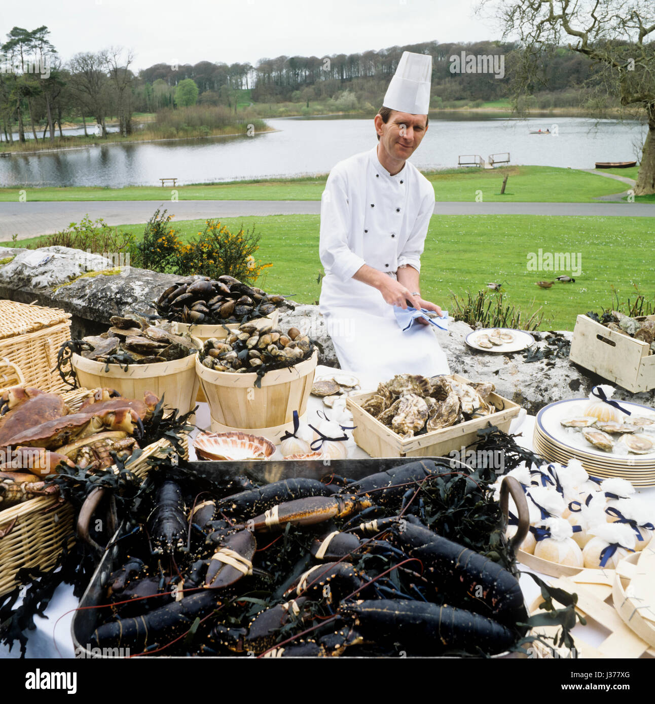 Chef next to table of assorted seafood. Stock Photo
