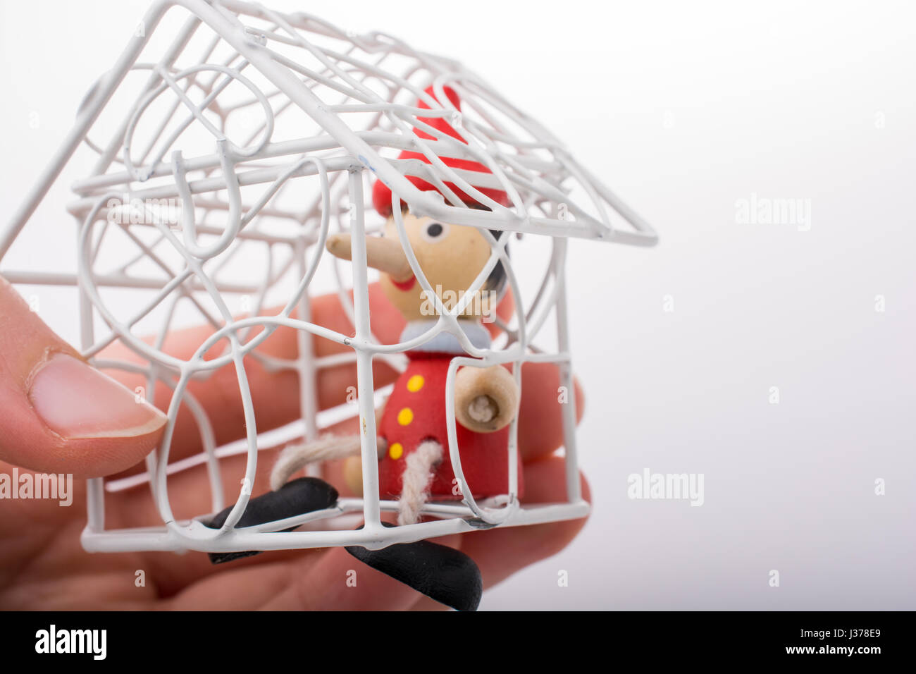 Hand holding a model house with pinocchio in it Stock Photo - Alamy
