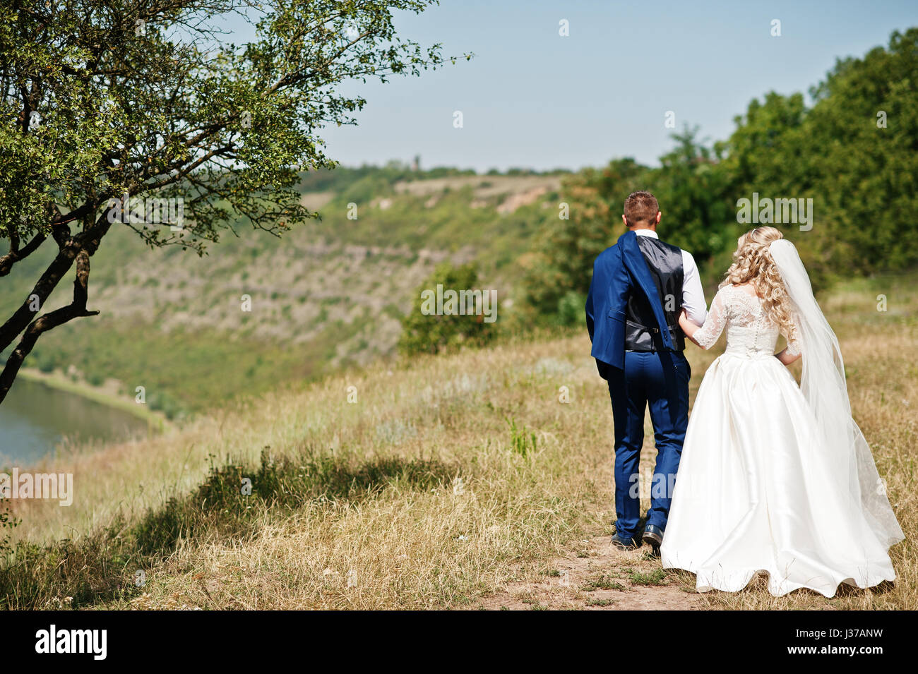 Happy wedding couple in love near trees on sunny day Stock Photo - Alamy