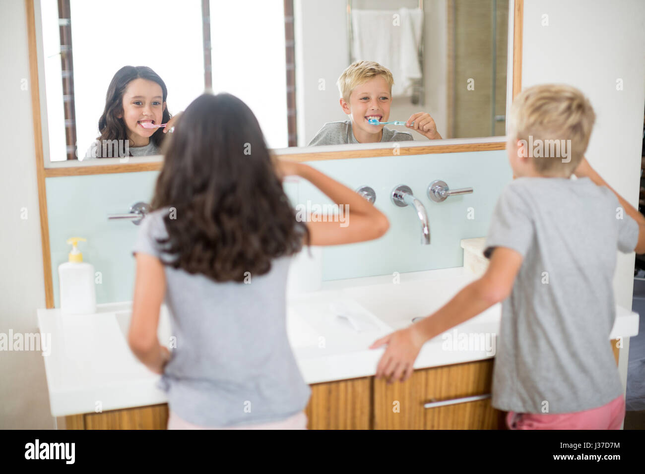 Siblings brushing their teeth in bathroom at home Stock Photo
